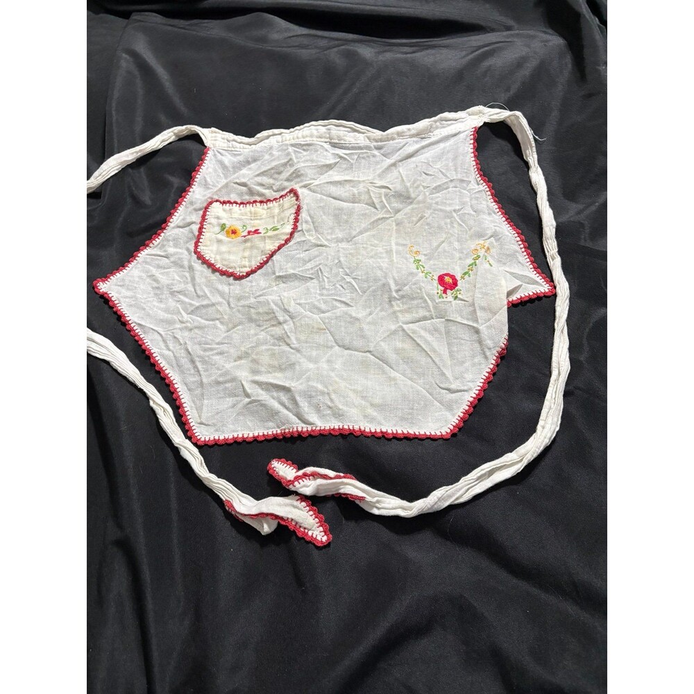 white vintage apron with crochet red trim and colorful embroidered floral detai